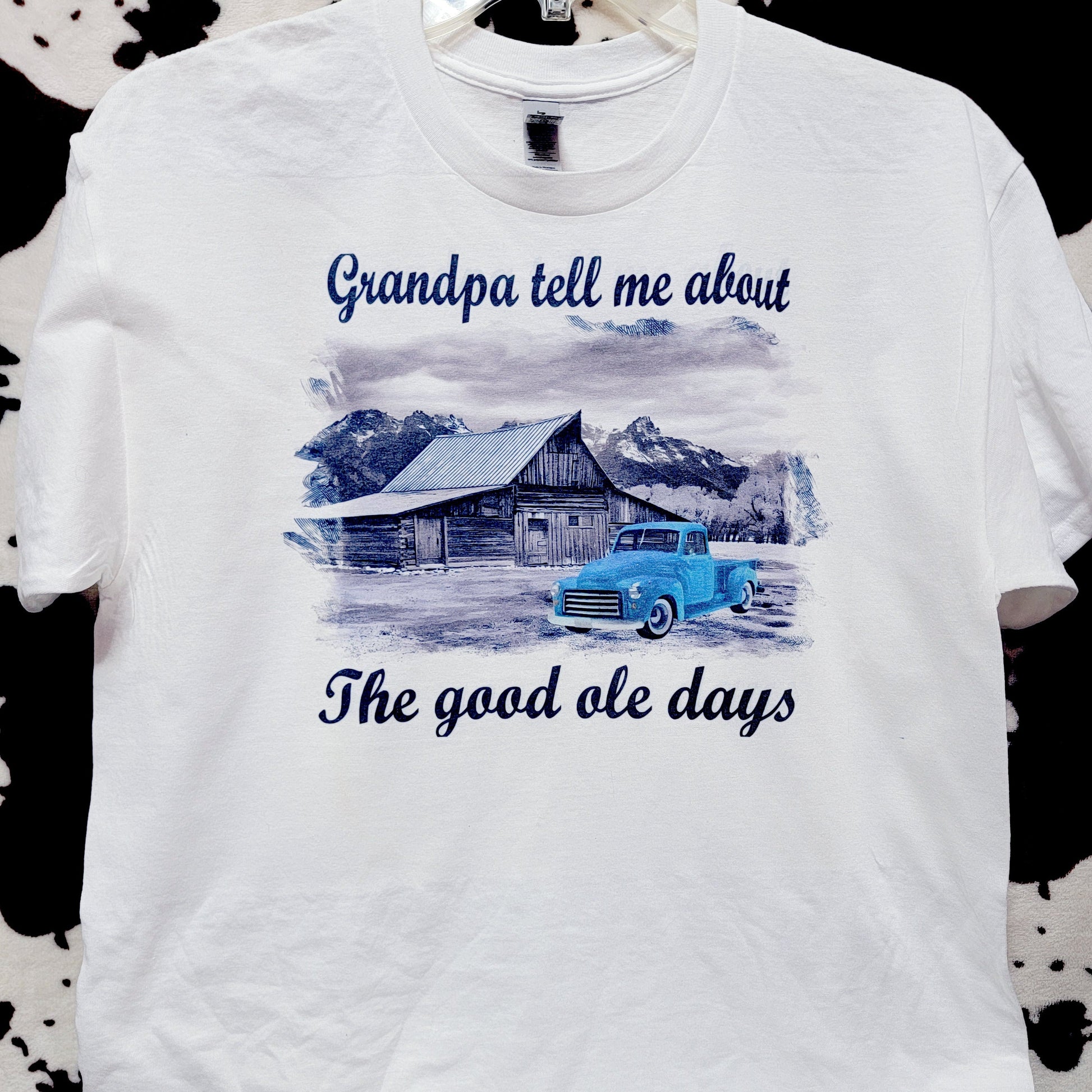 White t-shirt with graphic design and text on a patterned surface